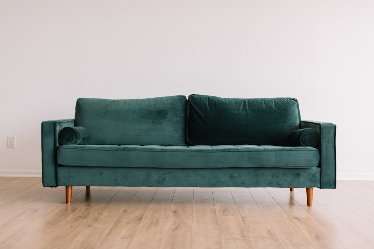 A teal velvet sofa with wood legs, shown as an example catalog product